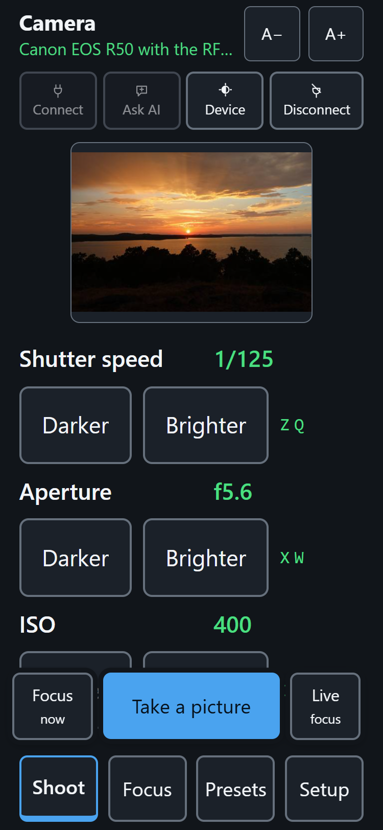 The app on a phone with live view open: a sunset over a lake fills the viewfinder, and under it Shutter speed 1/125, Aperture f5.6 and ISO 400, each with a large Darker and Brighter button and its own key.